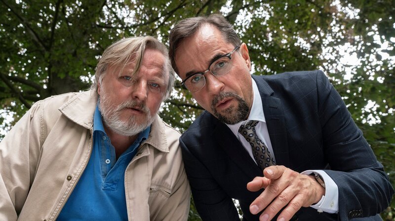 Frank Thiel (Axel Prahl, links) und Prof. Karl-Friedrich Boerne (Jan Josef Liefers) beugen sich über den Toten. – Bild: WDR/​Thomas Kost