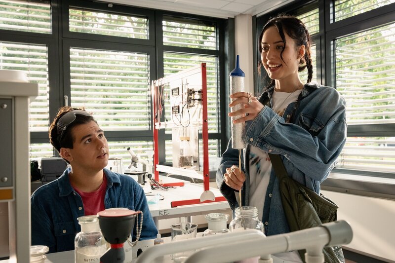 Ernst (Diyar Ilhan, l.) und Anna (Kayla Shyx, r.) im Chemielabor beim Bau einer Rakete: Während Ernst noch skeptisch ist, übernimmt Anna entschlossen die Rolle der Raketen-Ingenieurin. – Bild: ZDF und Michael Kötschau