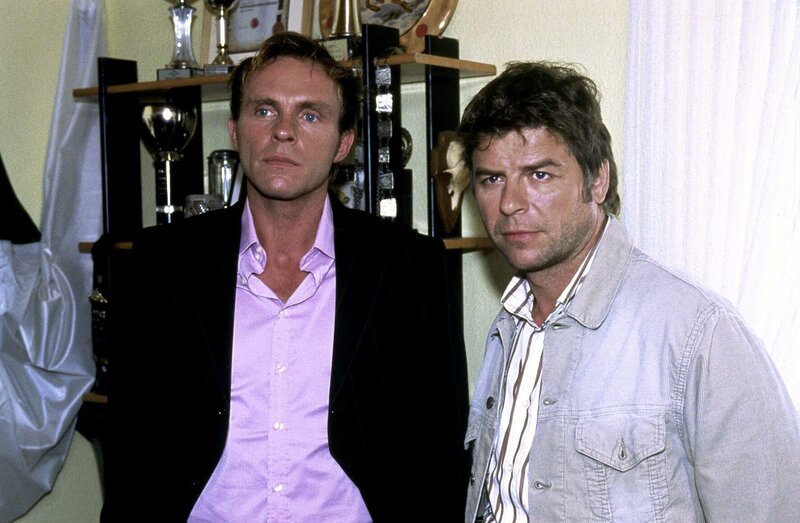 Sandra und Joachim Frings werden von Jupp (Uwe Fellensiek, r.) und Falk (Dirk Martens, l.) befragt. – Bild: SAT.1 /​ Münstermann