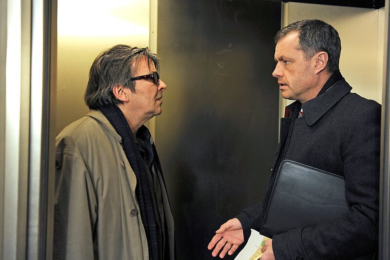 Nicos (Markus Graf, l.) hat sich unter falschem Namen im „Drei Könige“ einquartiert. Doch dann läuft er Torben (Joachim Kretzer, r.) direkt in die Arme … – Bild: ARD/​Nicole Manthey