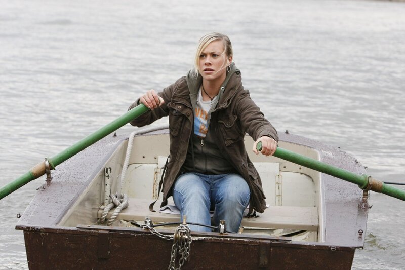 Sarah (Sina Tkotsch) wird von den Gangstern beschossen und versucht mit dem Ruderboot zu fliehen … – Bild: TVNOW /​ Guido Engels /​ Rabenmutter