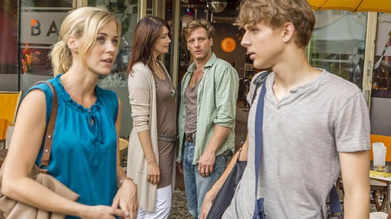 Stefan Vollmer (Hendrik Duryn) und Karin Noske (Jessica Ginkel, l.) stehen mit Jonas (Merlin Rose, r.) und seiner Mutter Simone (Claudia Mehnert) vor einem Schwulencafe. Könnte es sein, das Jonas der Sohn von Stefan ist? Und ist Jonas schwul? – Bild: TVNOW /​ Frank Dicks