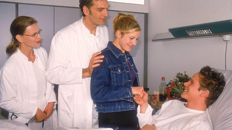 Schmidt (Walter Sittler, 2.v.l.), der wieder mal nur seinen Vorteil im Kopf hat, stellt Axel Winter (Maximilian Cress, lieg.) Nikolas Tochter Stephanie (Friederike Grasshoff) vor. (li. Kerstin Thielemann) – Bild: MG RTL D