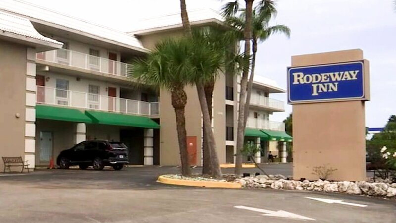 Das Rodeway Inn Motel ist mit einem Parkplatz und Palmen vor dem Eingang zu sehen. – Bild: Crime + Investigation /​ A+E Global Media
