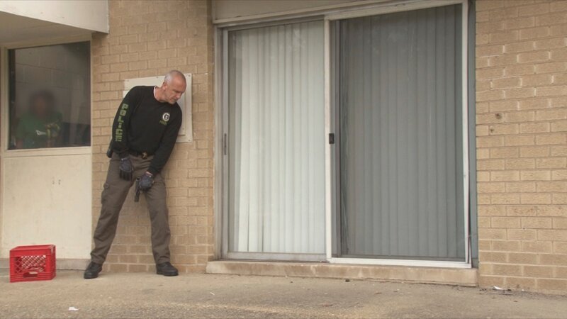 Der Polizist steht vor der Tür des Hauses – Bild: A&E