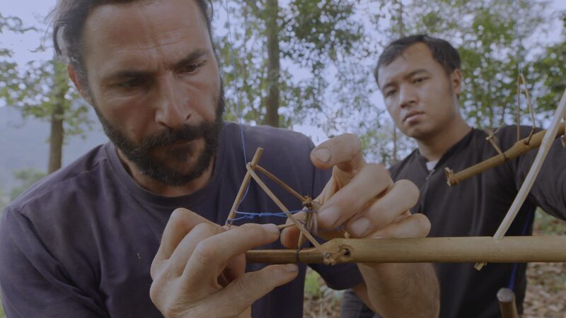 Hazen making a bird trap using a termite as bait. – Bild: National Geographic/​Alex Holden