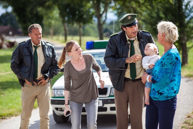 Lena Gründing (Katherine Brand, 2.v.l.) sucht mit der Hilfe von Hubert (Christian Tramitz, l.) und Staller (Helmfried von Lüttichau, 2.v.r. mit Komparsin) nach ihrem verschwundenen Baby. – Bild: ARD/​TMG/​Christian Hirschhäuser