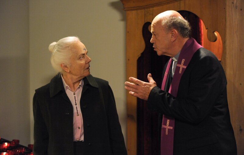 Pfarrer Kurz stellt erschrocken fest, dass Theres blaue Tintenflecken im Gesicht hat. Von links: Theresa Brunner (Ursula Erber) und Pfarrer Kurz (Hans Stadlbauer). – Bild: BR/​Marco Orlando Pichler