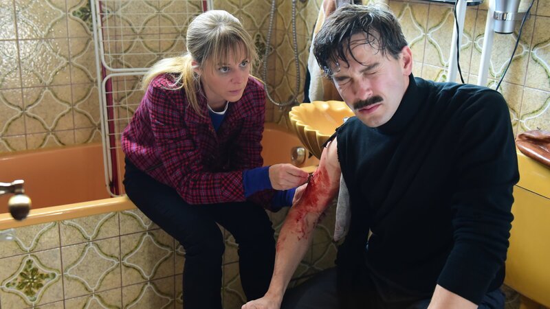 Angelika Flierl (Bernadette Heerwagen) leistet bei ihrem verletzten Entführer (Franz Dinda) erste Hilfe und näht eine Wunde. – Bild: ZDF