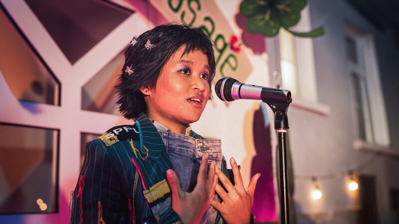 Massuda (Tisa Pharaschad Khumyim) steht am Mikro und findet die richtigen Worte. – Bild: MDR/​Carolin Reschke