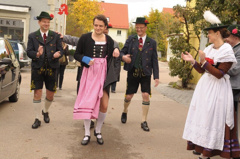 Flori (Tommy Schwimmer) muss zum Trachtenumzug im Dirndl gehen. – Bild: BR/​Jo Bischoff