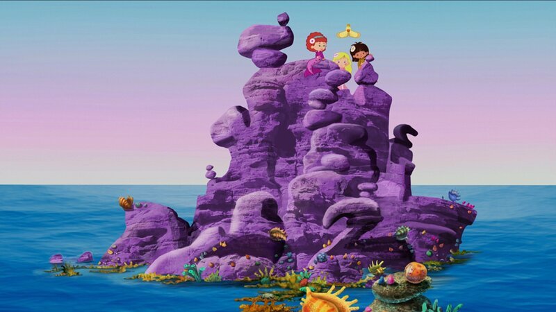 Hier sitzen Tanja, Zoé und Yasemin gemeinsam mit QuackQuack auf einem lila Felsen, der zu Tanjas Meer gehört. – Bild: KiKA