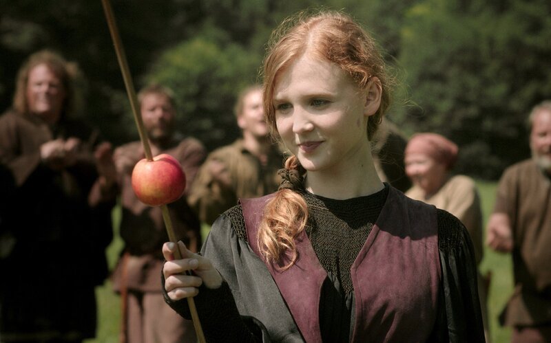 Prinzessin Elisabeth (Isolda Dychauk) schießt einen Pfeil in hohem Bogen in einen Apfel – Bild: Radio Bremen/​Jo Molitoris