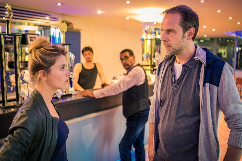 Resi Schwaiger (Mersiha Husagic, l.) spricht mit Lars Wagner (Alexander Wüst, r.); Franz Ainfachnur (Christofer v. Beau, 2. v.r.) steht bei Stanislaw Koslowski (Stipe Erceg, 2. v.l.) am Tresen. – Bild: ZDF und Markus Sapper