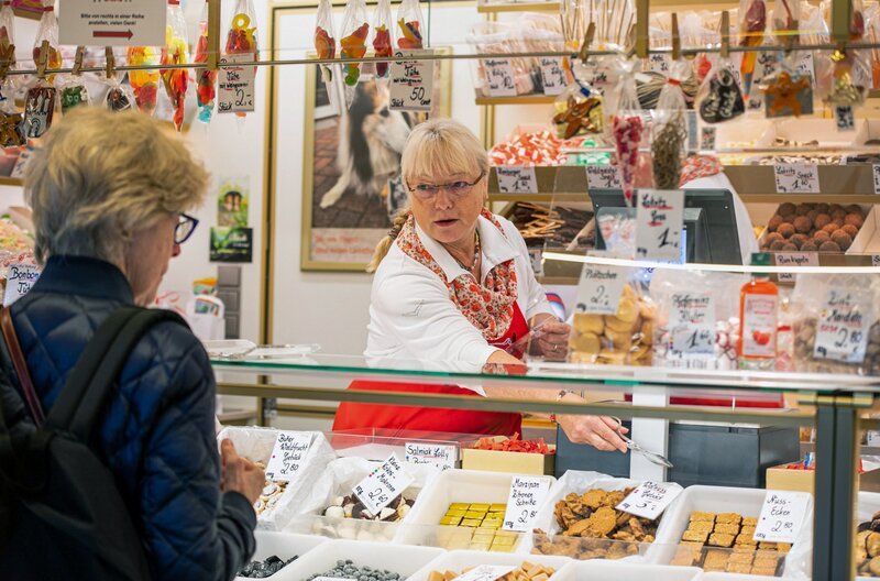 An einem der ältesten Stände des Isemarkts gibt es süße Leckereien. Sabine Pingel-Graßhoff hat vor einigen Jahren die Leitung des Familienunternehmens übernommen. – Bild: Beatrice Krol /​ An einem der ältesten Stände des Isemarkts gibt es süße Leckereien. Sabine Pingel-Graßhoff hat vor einigen Jahren die Leitung des Familienunternehmens übernommen.