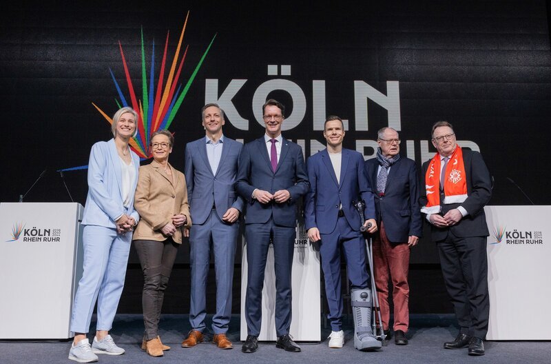 Start der Kampagne für die Bewerbung der Region Rhein-Ruhr um die Olympische und Paralympische Spiele in der Lanxess-Arena, Köln. V.l.n.r.: Britta Heidemann (ehemalige Fechterin), Isabell Werth (Dressurreiterin), Sebastian Schulte (ehemaliger deutscher Ruderer und Vorstandsvorsitzender der Deutz AG), Hendrik Wüst (Ministerpräsident von NRW, CDU), Markus Rehm (paralympischer Sportler), Peer Steinbrück (ehemaliger Ministerpräsident von NRW) und Torsten Burmester (Oberbürgermeister von Köln, SPD). – Bild: WDR/​Rolf Vennenbernd/​dpa