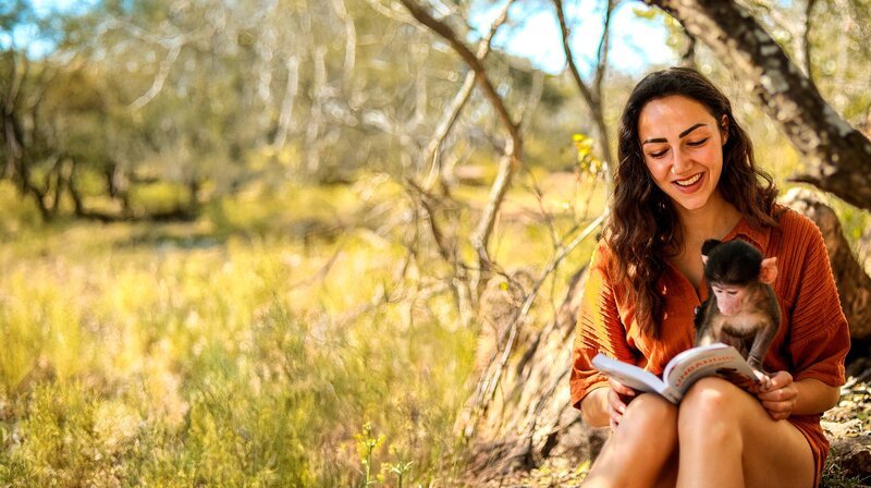 Michi mit dem acht Wochen alten Pavianbaby Bodhi, dessen Mama leider von Wildhunden getötet wurde. – Bild: WDR/​Michi und Marc Schreiber