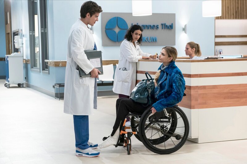 ARD PROGRAMMDIREKTION, IN ALLER FREUNDSCHAFT – DIE JUNGEN ÄRZTE, neue Vorabend-Weekly mit 42, Folgen 13 „Starke Mädchen“, am Donnerstag (23.04.15) um 18:50 Uhr im Ersten. Ben Ahlbeck (Philipp Danne, l.) will unbedingt die gutaussehnde Smilla Eriksson (Laura Berlin, r.) als Patientin betreuen. Weil er in der Eile die Patientenakte nicht richtig gelesen hat, tritt er ins Fettnäpfchen. Leyla Sherbaz (Sanam Afrashteh, M.), die alles mitbekommt, klärt ihn auf. – Bild: ARD/​Jens-Ulrich Koch