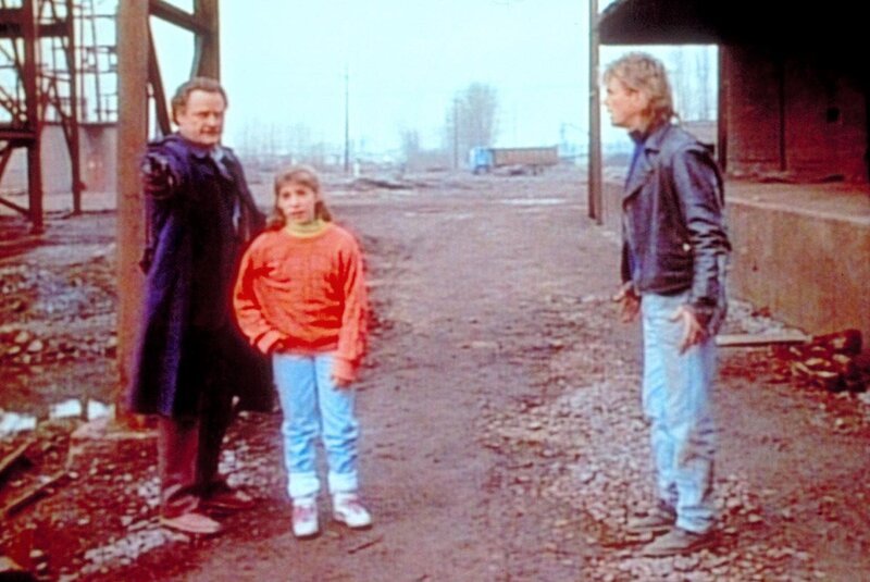 Travers (Ron Hale, l.) hat Lisa (Mayim Bialik, M.) in seiner Gewalt und bedroht ihren Vater. MacGyver (Richard Dean Anderson, r.) versucht, ihn zur Vernunft zu bringen. – Bild: ProSieben Media AG