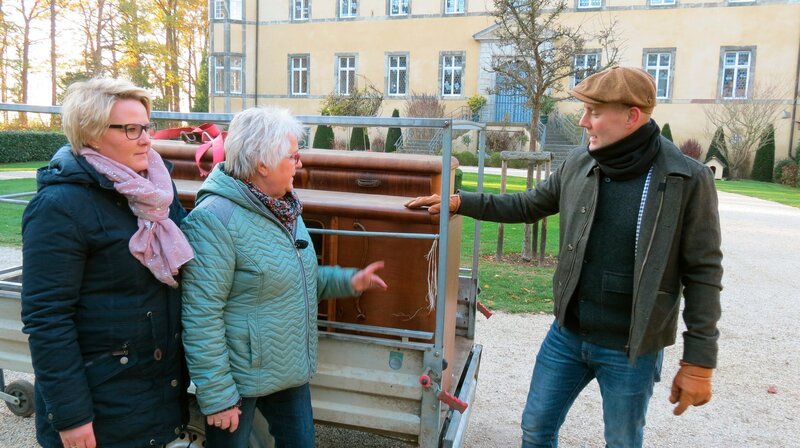 Oli P. bekommt von Almuth (m) und ihrer Tochter Julia (l) ein altes Küchenbuffet. – Bild: WDR/​Encanto Film- und Fernsehproduktions GmbH