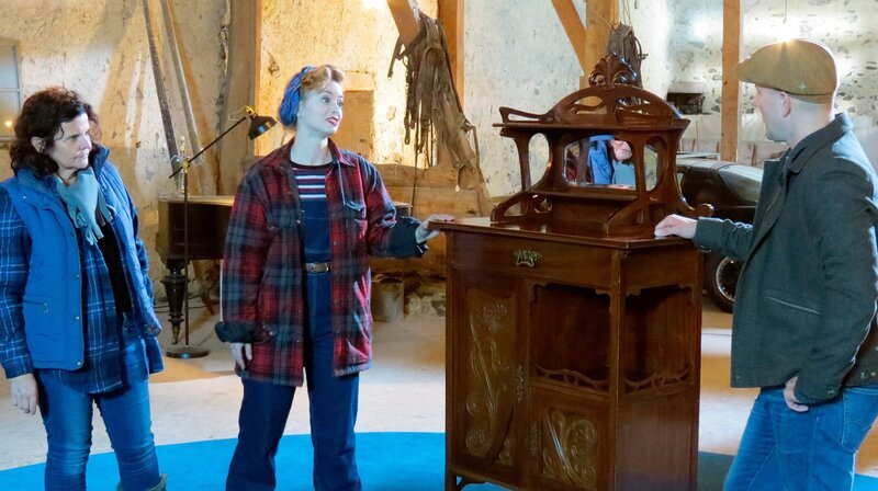 Restauratorin Marion Gerhards (l) inspiziert zusammen mit Victoria Beyer (m) und Oli P. (r) ein altes Jugendstil-Vertiko. – Bild: WDR/​Encanto Film- und Fernsehproduktions GmbH