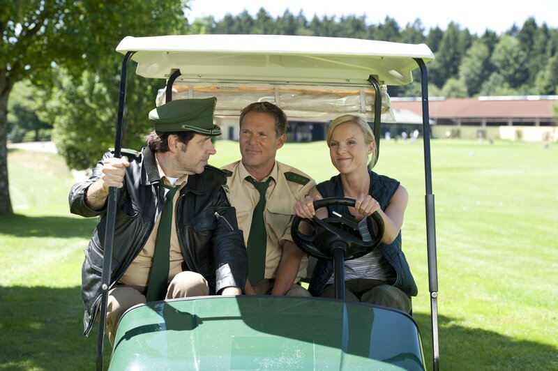 Johannes Staller (Helmfried von Lüttichau, links) und Franz Hubert (Christian Tramitz) ermitteln auf dem Golfplatz und befragen Julia Vogt (Kirstin Fischer). – Bild: TMG /​ Katrin Krammer