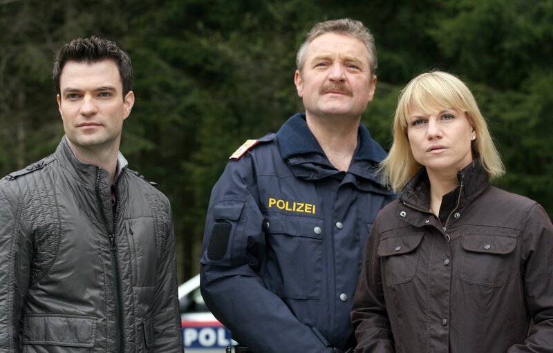 „Soko Kitzbühel“, „Ein klarer Schnitt.“ Beim Gieringer Weiher erliegt der Ex-Chirurg Jürgen Schindler einem Kopfschuss. Im Kofferraum seines Wagens macht die SOKO einen makabren Fund: Die abgetrennte Hand eines Mannes. Im Zuge der Ermittlungen werden die Kriminalisten mit einem medizinischen Phänomen konfrontiert: Es gibt Menschen, die sich von gesunden Gliedmassen trennen möchten, weil sie sie als „Fremdkörper“ empfinden. Der Mord am suspendierten Chirurgen scheint mit diesem Phänomen zu tun zu haben. Aber inwiefern berührt es die beiden Restauratoren Helene Deutsch und Frank Engerth, die in der Villa der Kunstsammlerin Andrea Kojani arbeiten? Und wieso findet sich Menschenblut in der Praxis eines Prominenten-Tierarztes? Im Bild (v.li.): Jakob Seeböck (Lukas Roither), Ferry Öllinger (Kroisleitner), Kristina Sprenger (Karin Kofler). – Bild: ORF/​BEO-Film/​Stella von Saldern