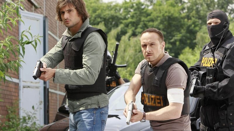 Ben (Tom Beck, li.), Semir (Erdogan Atalay) und das SEK machen sich zur Stürmung des Geländes bereit. – Bild: TVNOW /​ Guido Engels