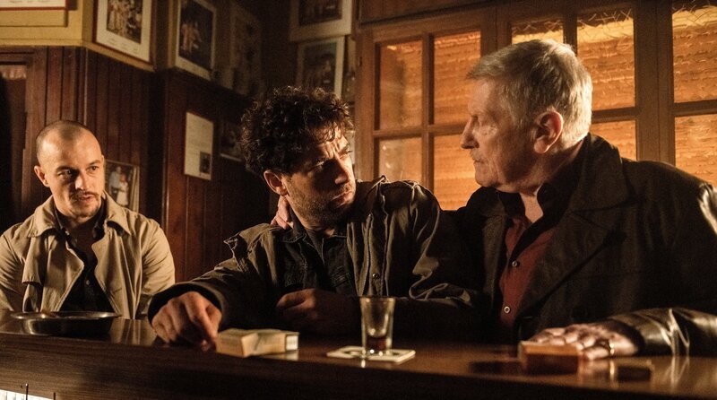 An der Theke von „Hugos Eck“: Karim Farooq (Timur Isik, Mitte) will in Ruhe etwas trinken. Doch Viktor Raschke (Manfred Zapatka, r) und Marco Raschke (Paul Wollin) haben nach ihm gesucht. – Bild: WDR/​Bavaria Fiction GmbH/​Martin Valentin Menke