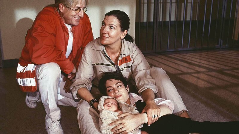 Walter (Katy Karrenbauer) und Richard Stern (Martin Semmelrogge) sind froh, dass das Baby von Susanne (Sheryl Shepard, vorne) heil auf die Welt gekommen ist. – Bild: RTL Deutschland