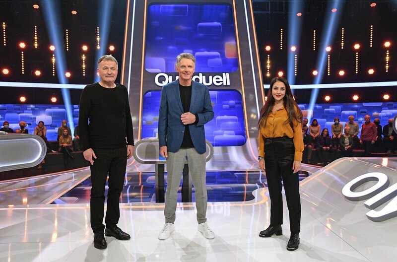 Moderator Jörg Pilawa (M.) mit den Kandidat:innen des Teams „TV-Klinik“: Dem Schauspieler Thomas Rühmann (l.) und der Schauspielerin Arzu Bazman (r.). – Bild: ARD/​Uwe Ernst