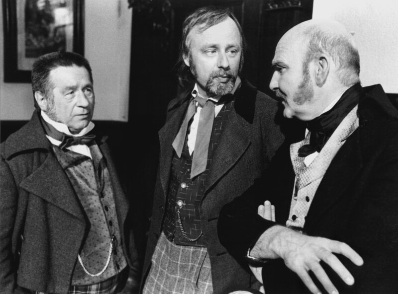 Notar Slusuhr (Dieter Wagner, rechts), David (Lutz Kraft, Mitte) und Pomuchelskopp (Joachim Wolff, links) haben eine geschäftliche Besprechung. – Bild: NDR/​Hassenstein