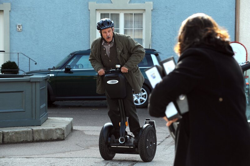 Schattenhofer (Werner Rom) saust mit seinem Turboroller zur Amtsstube. – Bild: BR/​Marco Orlando Pichler