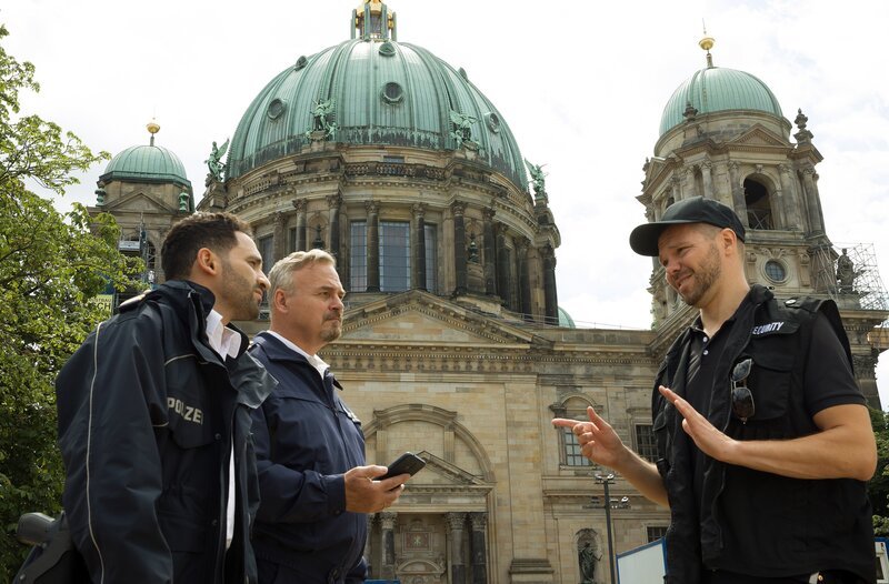 Vor dem Berliner Dom versucht Security-Mann Arne Litkowski (Martin Baden, r.) alles von sich zu weisen, womit ihn Fahri Celik (Hassan Akkouch, l.) und Axel Sommer (Oliver Breite. 2.v.l.) konfrontieren. – Bild: ARD/​Daniela Incoronato