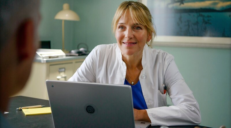 Nora Kaminski (Tanja Wedhorn) behandelt Dr. David Mandel (Marco Girnth) in ihrer Praxis. – Bild: ARD Degeto Film/​Arnim Thomaß
