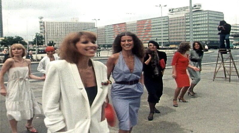 Das Jahr 1980 – die Ära der Hausbesetzungen und des illegalen Wohnens beginnt auf beiden Seiten der Mauer. Im Niemandsland des Potsdamer Platzes eröffnet ein Zirkus: das Tempodrom. In West-Berlin gründet sich die Band Ideal. Eine Berlin-Chronik der Superlative: 40 Folgen, Jahr für Jahr erzählt, von 1961, dem Jahr des Mauerbaus, bis zum neuen Jahrtausend 1999, zehn Jahre nach dem Mauerfall. Foto: Mode 1980 in Ost-Berlin – Models im Ostberliner Stadtbild. – Bild: rbb