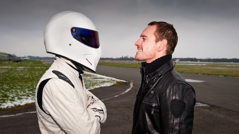 Hollywood-Star Michael Fassbinder (r.), heutiger Protagonist in „Das preiswerte Auto“, mit „The Stig“. – Bild: RTL NITRO /​ BBC Worldwid