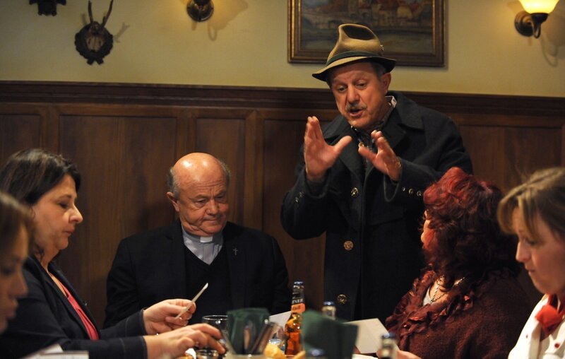 Schattenhofer hat den Landfrauen und Pfarrer Kurz etwas Wichtiges mitzuteilen. Von links: Pfarrer Kurz (Hans Stadlbauer) und Bürgermeister Schattenhofer (Werner Rom). – Bild: BR/​Marco Orlando Pichler