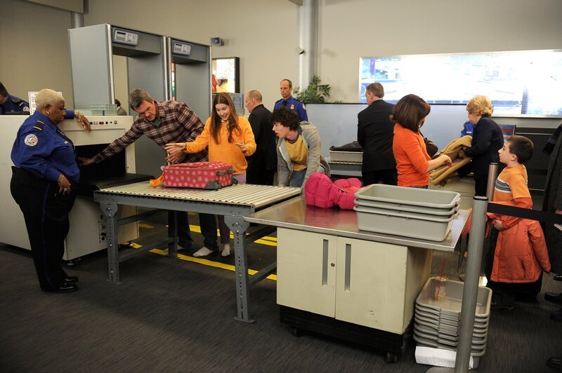 Eigentlich freuen sich die Hecks auf einen entspannten Trip nach New York: Doch dann entwickelt Mike (Neil Flynn, l.) Flugangst, während sich Sue (Eden Sher, 2.v.l.) und Axl (Charlie McDermott, M.) in die Haare kriegen, Frankie (Patricia Heaton, 2.v.r.) die Sicherheitsbeamtin (Luenell, Cambell, vorne) beleidigt und Brick (Atticus Shaffer, r.) auf der dringenden Suche nach Büchern ist … – Bild: Warner Brothers Lizenzbild frei