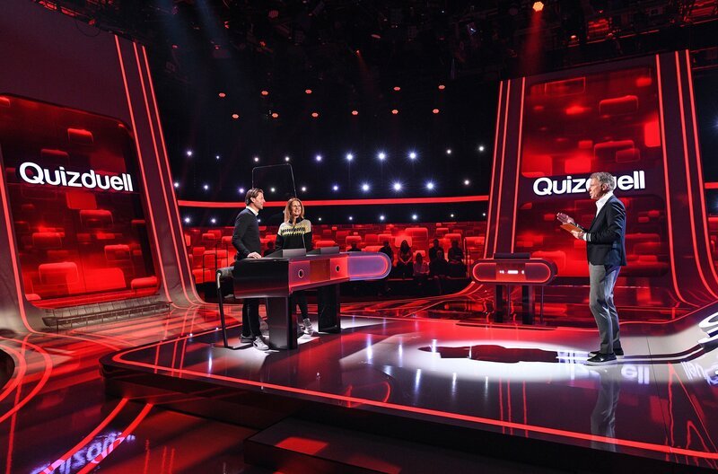 Moderator Jörg Pilawa (r.) mit den Kandidaten des Teams „Anstoss“: Dem Ex-Profifussballer Roman Weidenfeller (l.) und der Sportjournalistin und Moderatorin Katrin Müller-Hohenstein (2.v.l.). – Bild: ARD/​Uwe Ernst