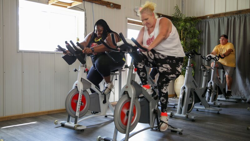 L-R: Ashely and Vannessa take a spin class at Fit Farm. – Bild: TLC /​ Discovery images: ZEUU206_1KBF_2 /​ © 2022, Discovery, Inc. All Rights Reserved.