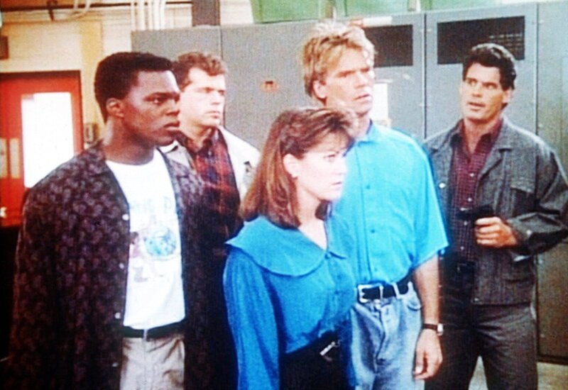 Breeze (Charles Andrew Payne, l.), Laura (Julie Downing) und MacGyver (Richard Dean Anderson, 2.v.r.) werden von Wyatt (Dan Muldoon, r.) und Evers (Antony Ulc, 2.v.l.) in Schach gehalten. – Bild: Kabel Eins Classics