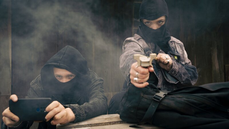 Robert „Robbie“ Lichtenberg (Michelangelo Fortuzzi) und Nina Glanz (Bineta Hansen) attackieren die Polizei und filmen das Ganze. – Bild: Christine Schroeder /​ ZDF