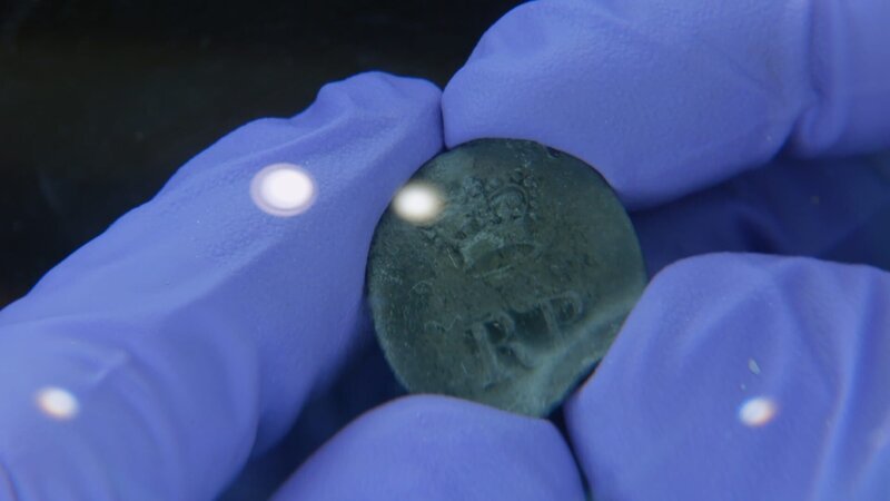 Pewter button CU from Storm Wreck. (National Geographic/​Mark Molesworth) – Bild: National Geographic /​ Mark Molesworth