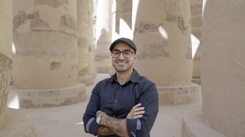 Arto Belekdanian steht mit verschränkten Armen in Medinet Habu. – Bild: Windfall Films /​ Celestine Fünfgeld