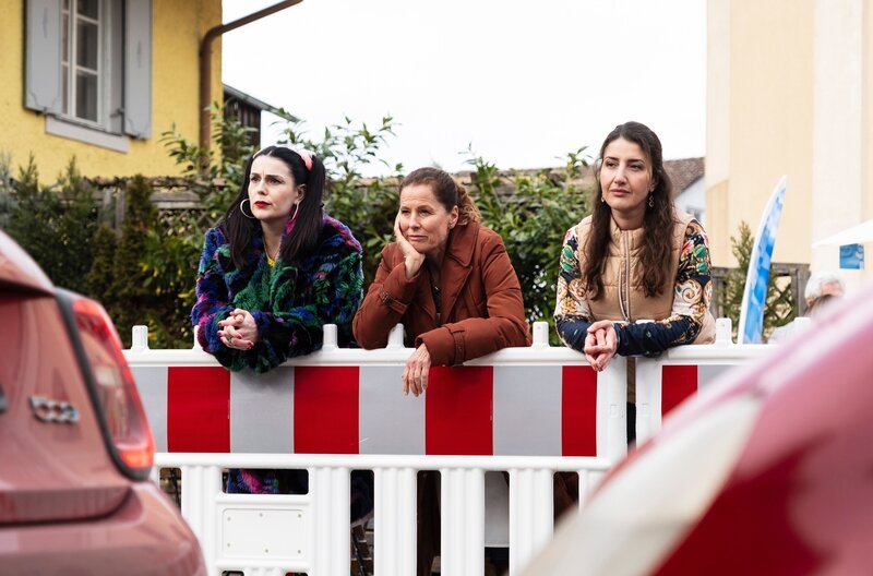 Rana, Annalena und Tina beobachten den Durchgangsverkehr an der Umleitung. Von links: Tina (Anita Eichhorn), Annalena (Heidrun Gartner) und Rana (Gonca de Haas). – Bild: BR/​Lena Semmelroggen