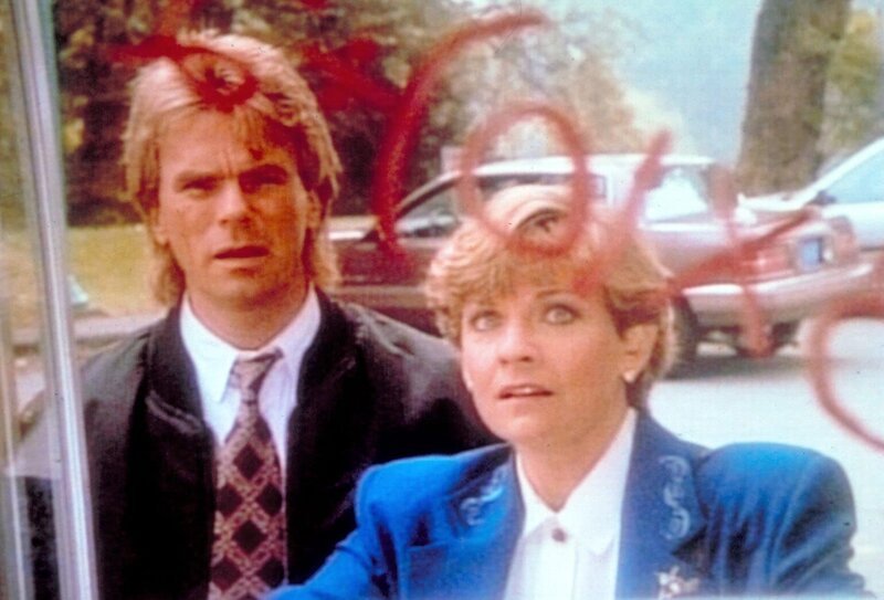 Eine einfache Rechenaufgabe auf einer Telefonzelle stellt MacGyver (Richard Dean Anderson, l.) und Lieutenant Murphy (Kim Zimmer, r.) vor eine scheinbar unlösbare Aufgabe. – Bild: Kabel Eins Classics