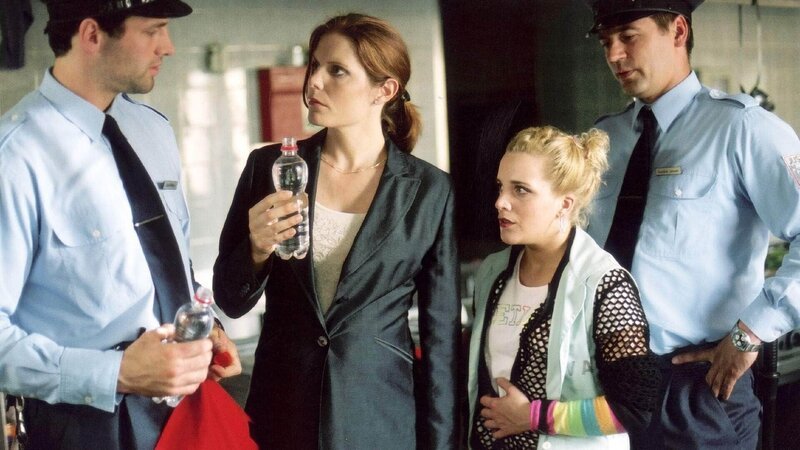 David (Jost Pieper, li.) hat geschmuggelten Alkohol in Kims (Judith Hildebrandt, 2.v.re.) Tasche entdeckt. Er und die Anstaltsleiterin Miriam Overberg (Cornelia Schindler) ahnen nicht, dass sein Kollege Hendrik dabei die Finger im Spiel hat … – Bild: TVNOW /​ Richard Hübner