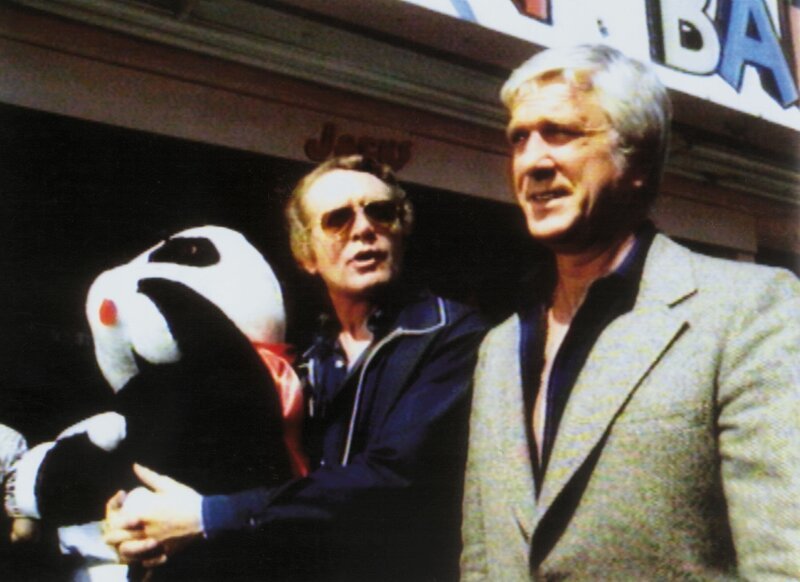 Nelson Brenner (Patrick McGoohan, li.) trifft sich mit Geronimo (Leslie Nielsen) auf einem Rummelplatz. – Bild: RTLup