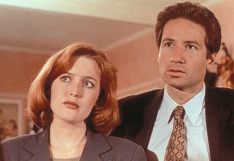 Mulder (David Duchovny, r.) und Scully (Gillian Anderson, l.) wollen es zunächst nicht glauben, als ihnen ein offenbar hellseherisch begabter Versicherungsvertreter erzählt, wo sie die Leiche einer kürzlich ermordeten Wahrsagerin finden werden. – Bild: ProSieben MAXX